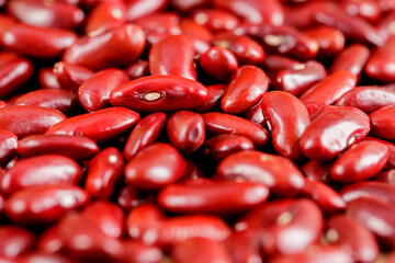 Closeup red beans or kidney bean in wooden bowl isolated on wood table background.