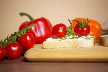 toast bread with tomato and pepper spread and chives on a wooden board
