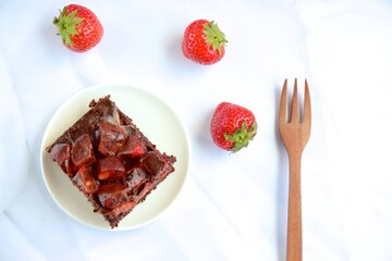 Strawberry chocolate brownies with fresh strawberry and chocolate sauce. Flat lay