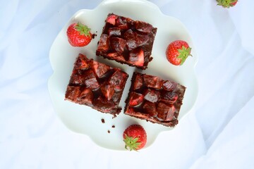 Strawberry chocolate brownies with fresh strawberry and chocolate sauce