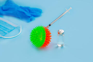 Vaccines and syringes, face mask on blue background.