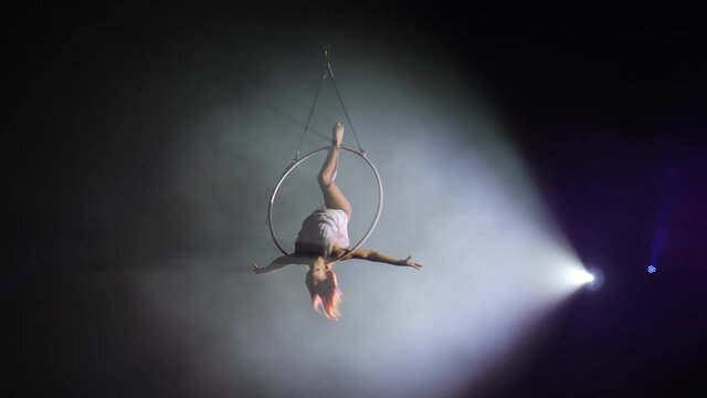 Young girl performs the acrobatic elements in the air ring