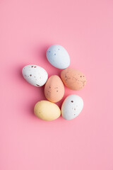 Colorful chocolate easter eggs. Sweet candy eggs on pink background.