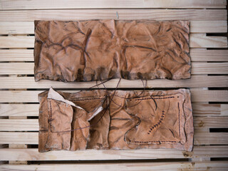 Leather pouch made of zombie skin with scars stitched with brown thread top view