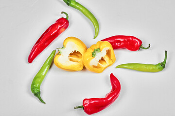 Slices of bell peppers and chili peppers on white background