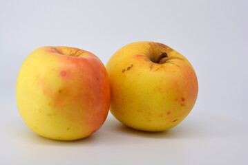 Small ripe yellow apples with red sideways located on a white background. 