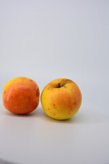 Small ripe yellow apples with red sideways located on a white background. 