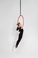 Little acrobat girl shows an acrobatic performance on an aerial hoop © Rychko Yevhen
