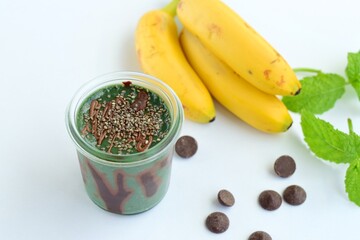 Spirulina mint banana smoothie with chocolate and chia seeds. White background