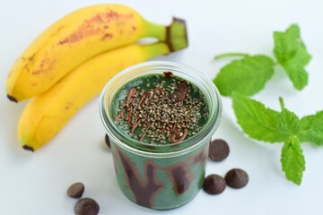Spirulina mint banana smoothie with chocolate and chia seeds. White background
