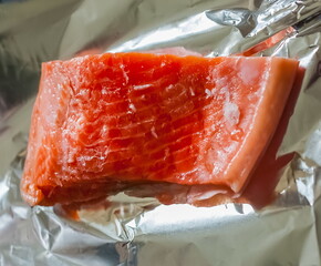 A piece of fish the salmon on the aluminum foil food closeup