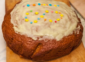 Glazed cake with lined pastry figures figures on a wooden cutting Board close up