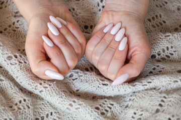 Model woman showing light pale pink nude shellac manicure on long nails