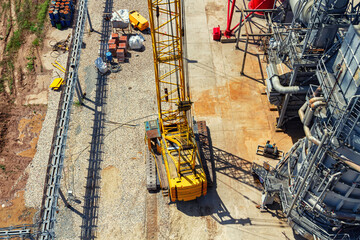 A large yellow crawler crane stands at the bottom of reactor