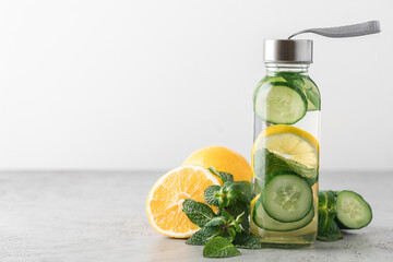 Lemon, cucumber and mint water in glass bottle. Sassy water for detox or dieting on white background. Healthy eating, weight loss, lifestyle concept