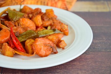 Sambal goreng kentang udang. Fried cubed potato with prawns cooked with coconut milk and spices (Indonesian food)
