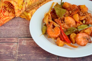 Sambal goreng kentang udang. Fried cubed potato with prawns cooked with coconut milk and spices (Indonesian food)