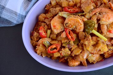 Sambal goreng kentang udang. Fried cubed potato with prawns cooked with coconut milk and spices (Indonesian food)