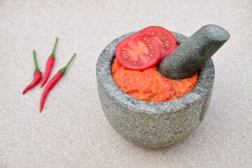 Homemade sambal tomat (spicy tomato sambal) in mortar and pestle 