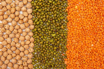 a mixture of cereals chickpeas, peas, lentils, mash, buckwheat laid out in a row on a white background close-up