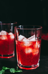 Strawberry rosemary tonic. Dark and moody photo. Focus in froht of glass.