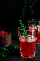 Strawberry rosemary tonic. Dark and moody photo. Focus in froht of glass.