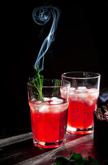 Strawberry rosemary tonic. Dark and moody photo. Focus in froht of glass.
