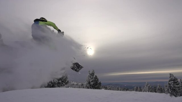 riding with jumps on mountain snow bike on fresh snow with swirls and splashes. snow motorcycles and winter tourism. snowmobile outdoor activities