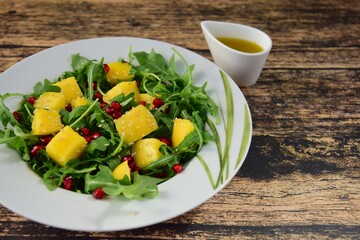 Arugula salad with mango and pomegranate served with Vinaigrette dressing