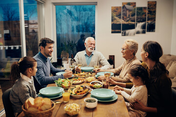 Fototapeta na wymiar Happy multi-generation family talking during lunch in dining room.