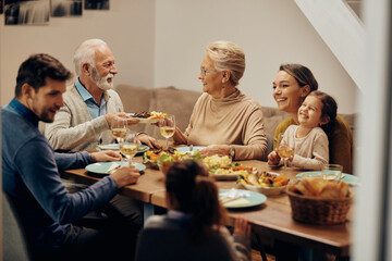 Happy multi-generation family enjoying in a lunch at dining table.