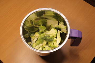 Broccoli into a bowl isolated in wood background