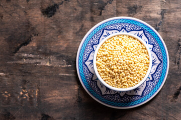 Dry ptitim close-up. Toasted pasta ptitim (petit plomb or Israeli couscous)  on a wooden background.