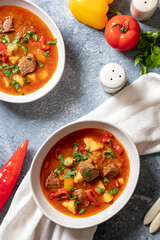 goulash is a traditional Hungarian dish with beef, potatoes, tomatoes and peppers. goulash in white...
