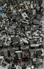 A huge pile of old cameras piled on the floor