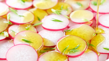 pouring olive oil on salad with radish and green onion. Vegetable Fresh Salad