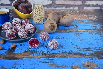 Beetroot quinoa date almond coconut energy balls on blue wooden background