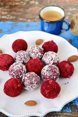 Beetroot quinoa date almond coconut energy balls on blue wooden background