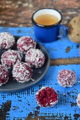 Beetroot quinoa date almond coconut energy balls on blue wooden background