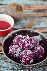 Beetroot quinoa date almond coconut energy balls on blue wooden background