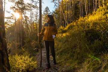 A young girl on a trek through the woods one afternoon at sunset. Artikutza forest in Oiartzun, Gipuzkoa. Basque Country