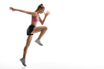 Fototapeta na wymiar In air. Caucasian professional female athlete, runner training isolated on white studio background. Muscular, sportive woman. Concept of action, motion, youth, healthy lifestyle. Copyspace for ad.