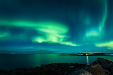 Fototapeta na wymiar Aurora Borealis on the night sky above the sea