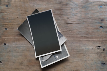 stack of old photographic paper on vintage paper with edging track for inner side on natural wood background, concept family genealogy, memories, generational ties