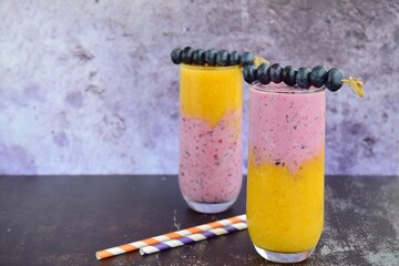 Fresh blueberry mango layer smoothie with blueberry skewers