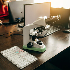 A doctor sits in a laboratory and makes a study under a microscope