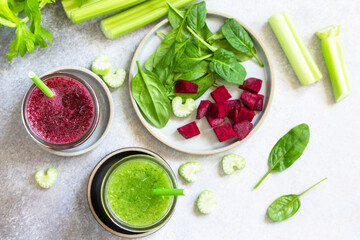 Vegan diet and nutrition, healthy detox, vegetarian concepts drinks. Beet smoothie and Green smoothie celery and spinach on a gray stone countertop. Top view flat lay.