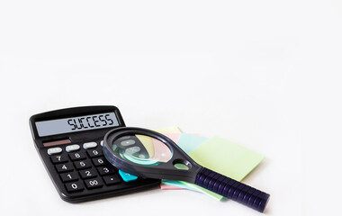 Success text on a calculator. Business concept on white background calculator, stickers and...