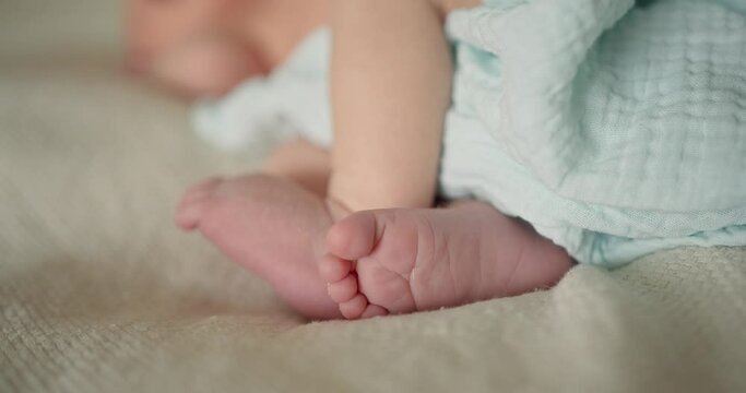 Tiny feet of newborn baby. Real time of crop infant baby moving with small feet
