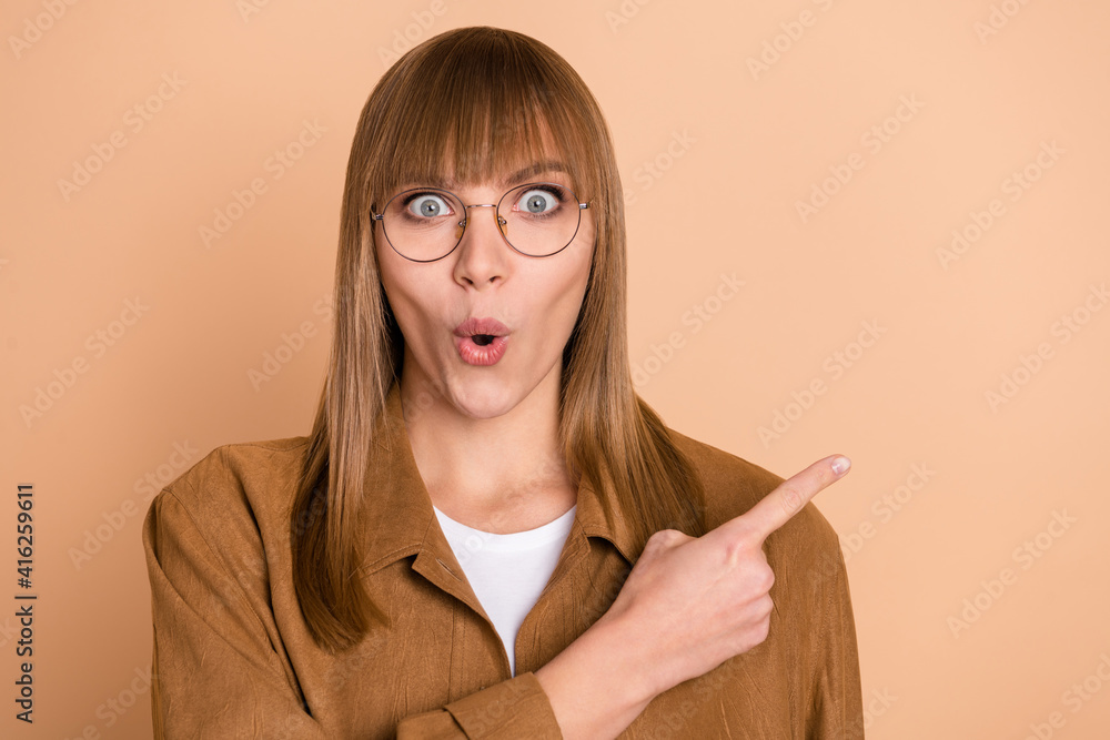 Sticker photo of shocked young woman point index finger empty space unexpected sale news isolated on beige c